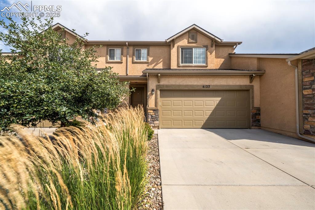 Image 3 of 34: View of the front of the home showcasing a 2-car garage, stucco exterior, l