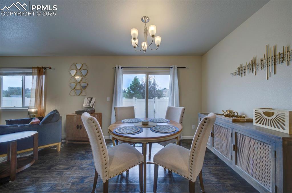 Image 7 of 34: Dining space with wood finished floors and a chandelier