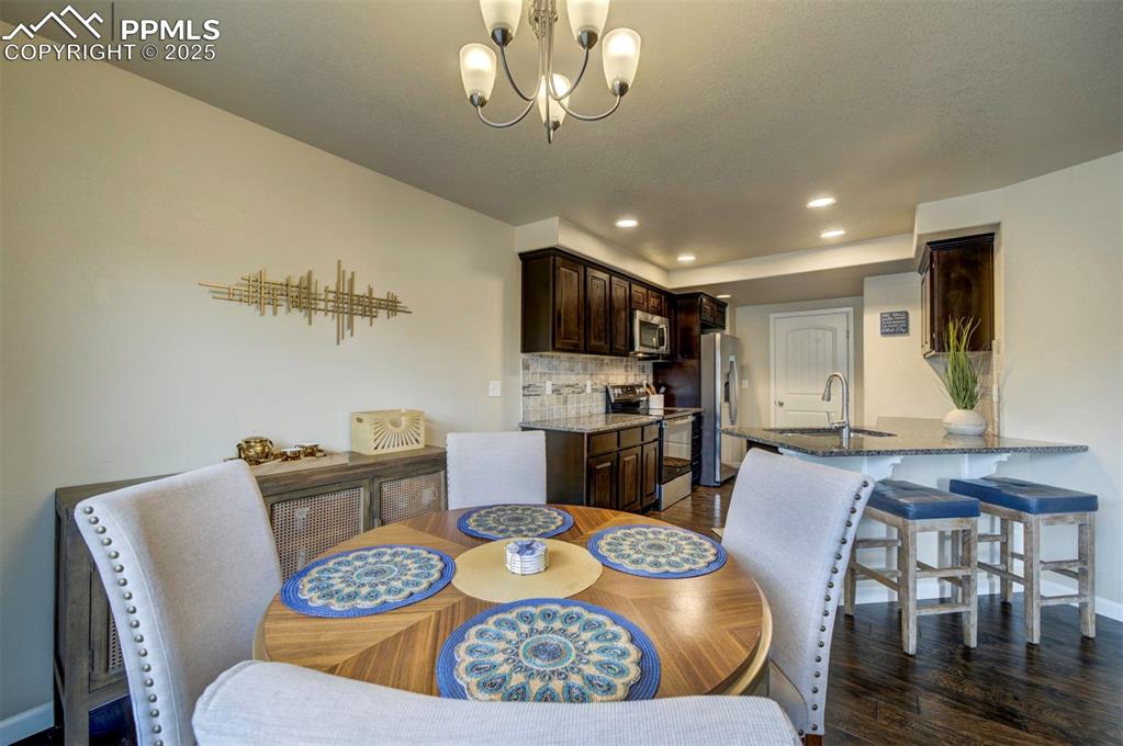 Image 8 of 34: Dining area featuring recessed lighting, dark wood-style flooring, and a ch