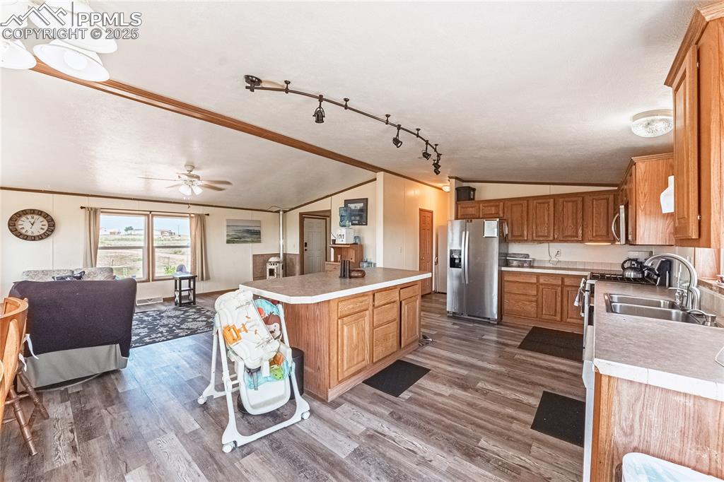 Image 12 of 48: Kitchen with stainless steel appliances, vaulted ceiling, light countertops