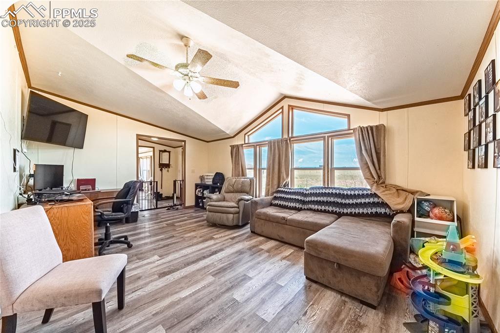 Image 16 of 48: Office space with wood finished floors, vaulted ceiling, ceiling fan, a tex