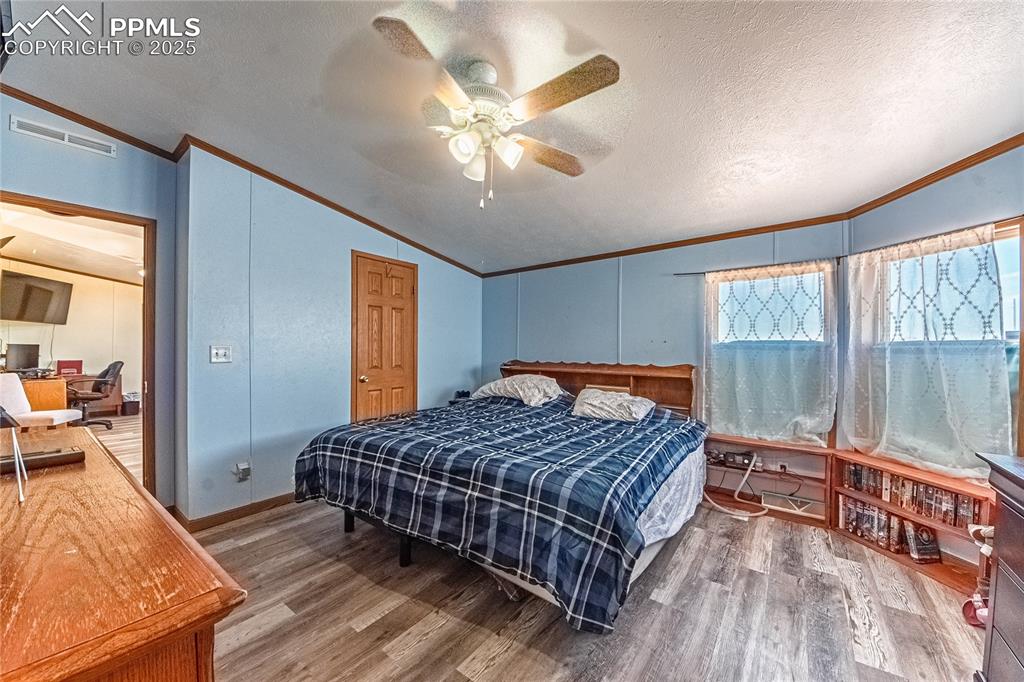 Image 18 of 48: Bedroom featuring crown molding, lofted ceiling, wood finished floors, ceil