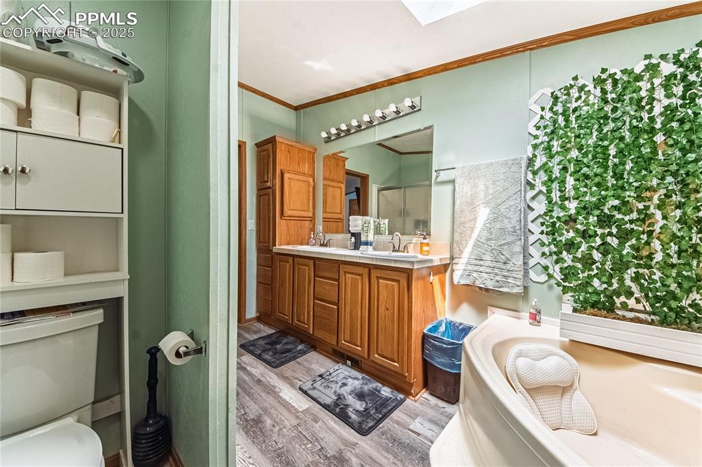 Image 23 of 48: Full bath featuring wood finished floors, a shower stall, crown molding, va