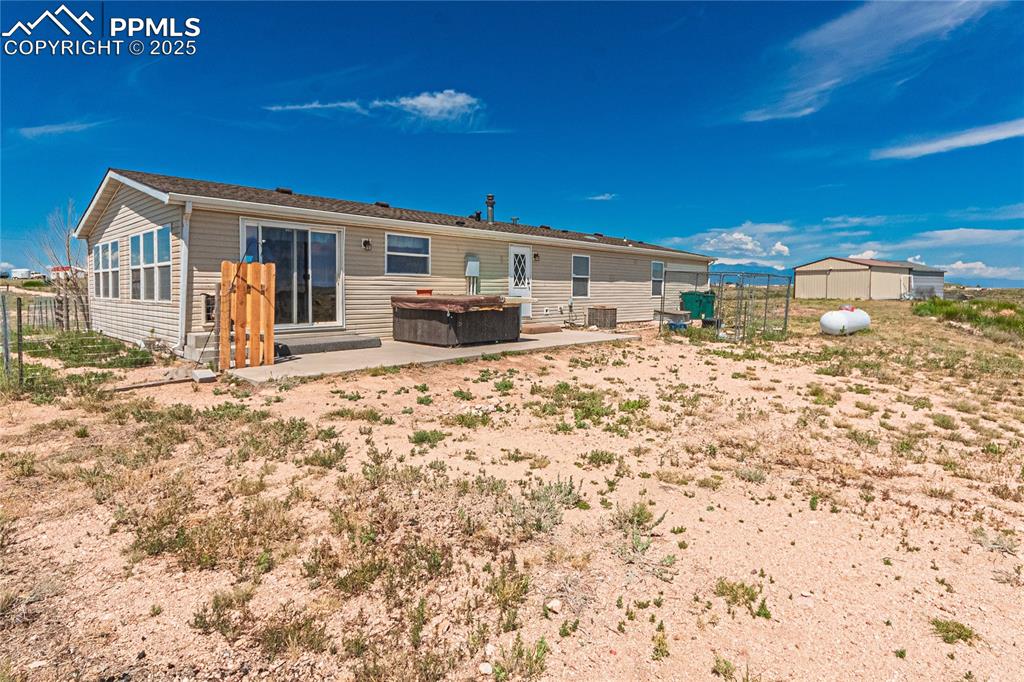 Image 39 of 48: Rear view of property featuring a hot tub and a patio