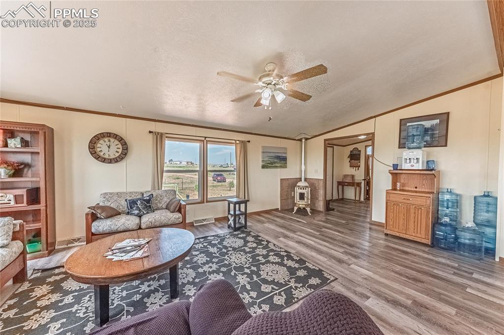 Image 4 of 48: Living area featuring wood finished floors, a ceiling fan, vaulted ceiling,