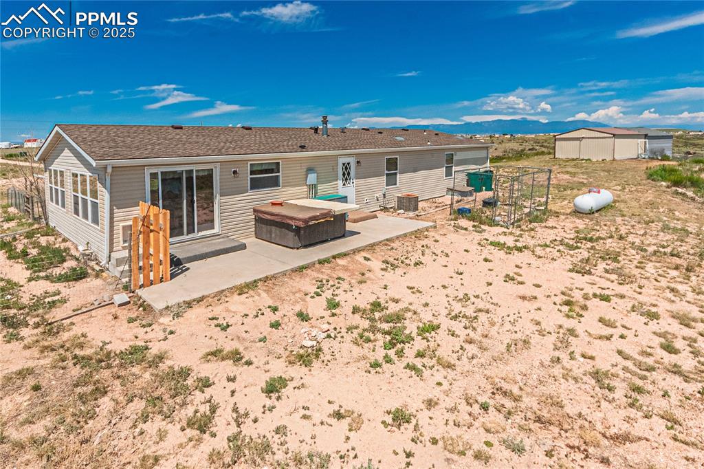 Image 40 of 48: Back of property featuring a patio and an outdoor structure