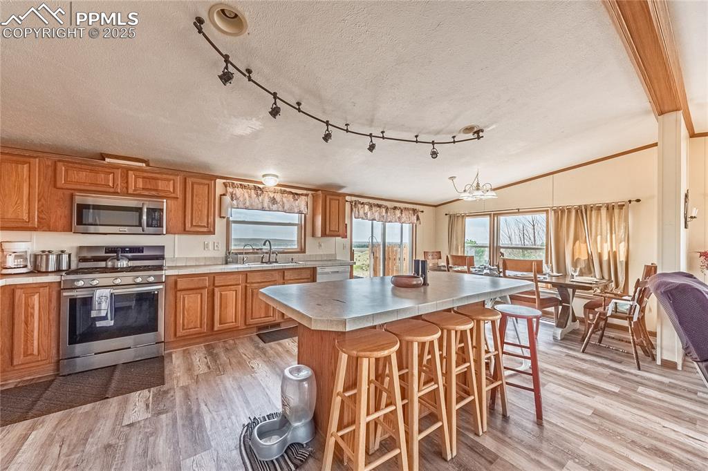 Image 5 of 48: Kitchen featuring appliances with stainless steel finishes, light wood-styl