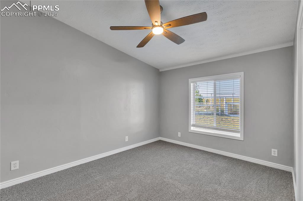 Image 18 of 34: Carpeted empty room featuring ceiling fan and a textured ceiling