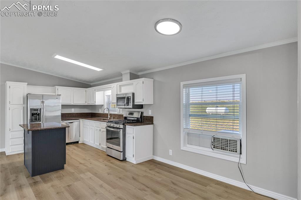 Image 5 of 34: Kitchen with appliances with stainless steel finishes, a kitchen island, li