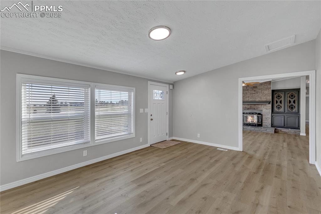 Image 7 of 34: Foyer featuring a textured ceiling, light hardwood / wood-style floors, a w