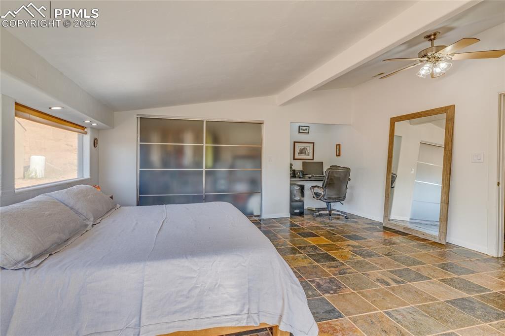 Image 13 of 47: Bedroom with tile flooring, lofted ceiling with beams, and ceiling fan