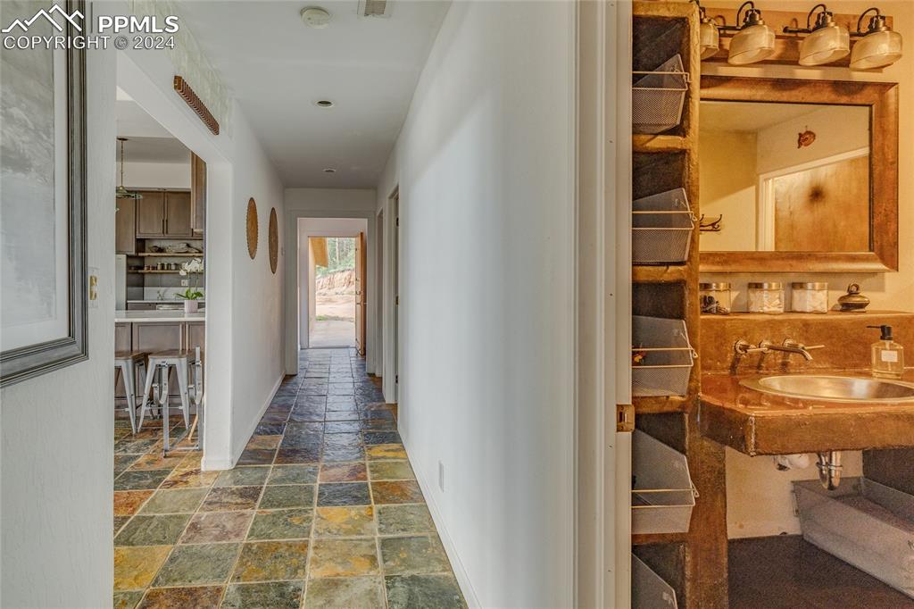 Image 19 of 47: Corridor featuring tile floors and sink