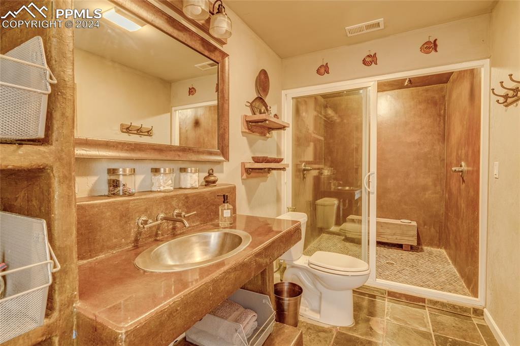 Image 20 of 47: Bathroom featuring vanity, tile flooring, toilet, and tiled shower