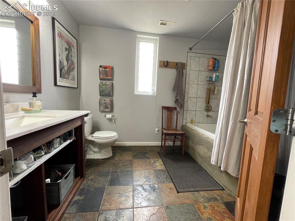 Image 22 of 47: Full bathroom featuring vanity, shower / bath combination with curtain, toi