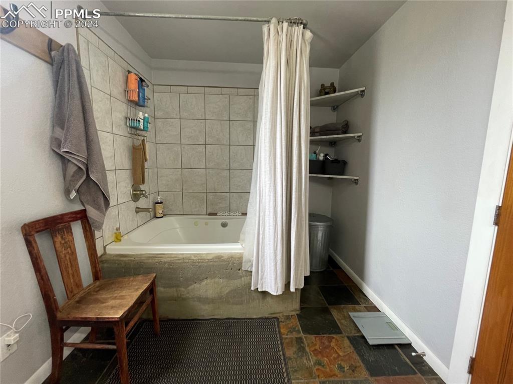 Image 23 of 47: Bathroom with tile floors and shower / tub combo