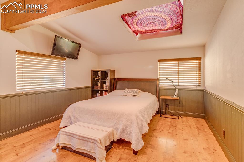Image 24 of 47: Bedroom featuring lofted ceiling and light wood-type flooring