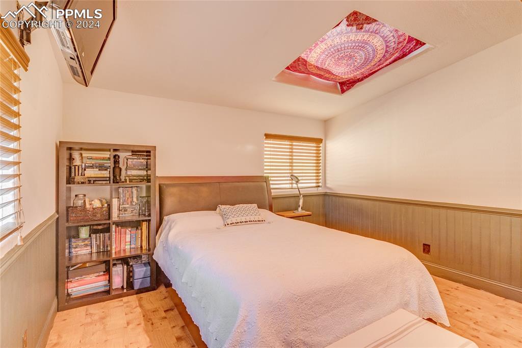 Image 25 of 47: Bedroom featuring a wall mounted AC and light hardwood / wood-style floors