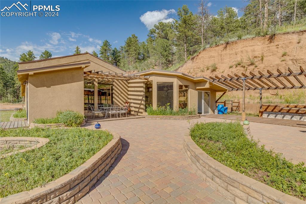Image 28 of 47: View of front of house with a pergola and a patio