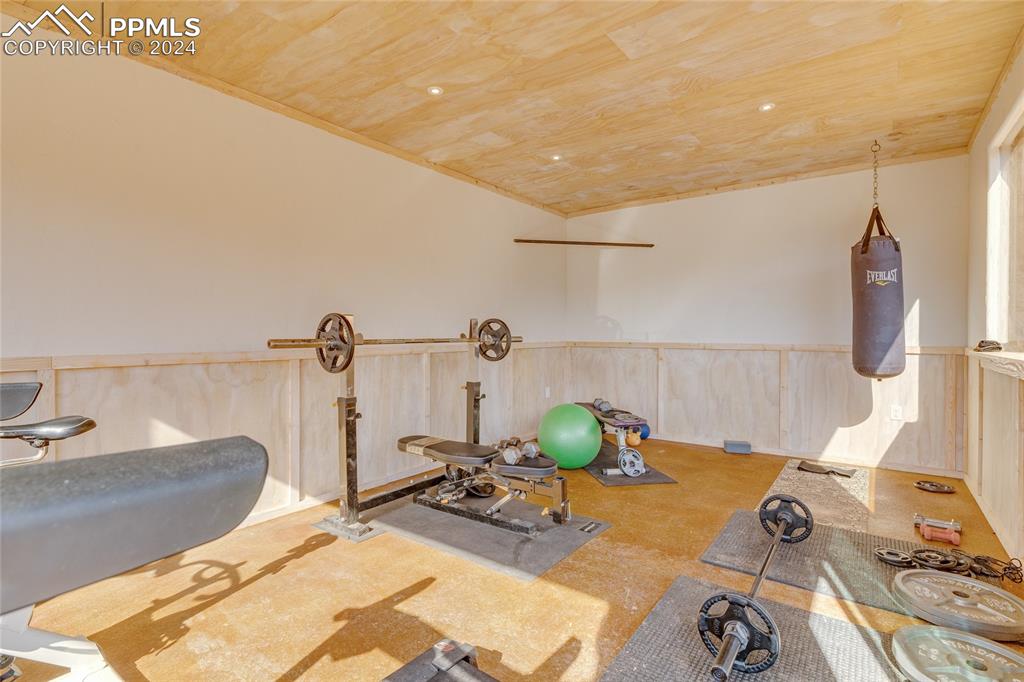 Image 44 of 47: Exercise room featuring wooden ceiling