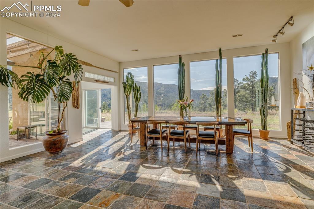 Image 8 of 47: Sunroom / solarium featuring track lighting, a mountain view, ceiling fan,