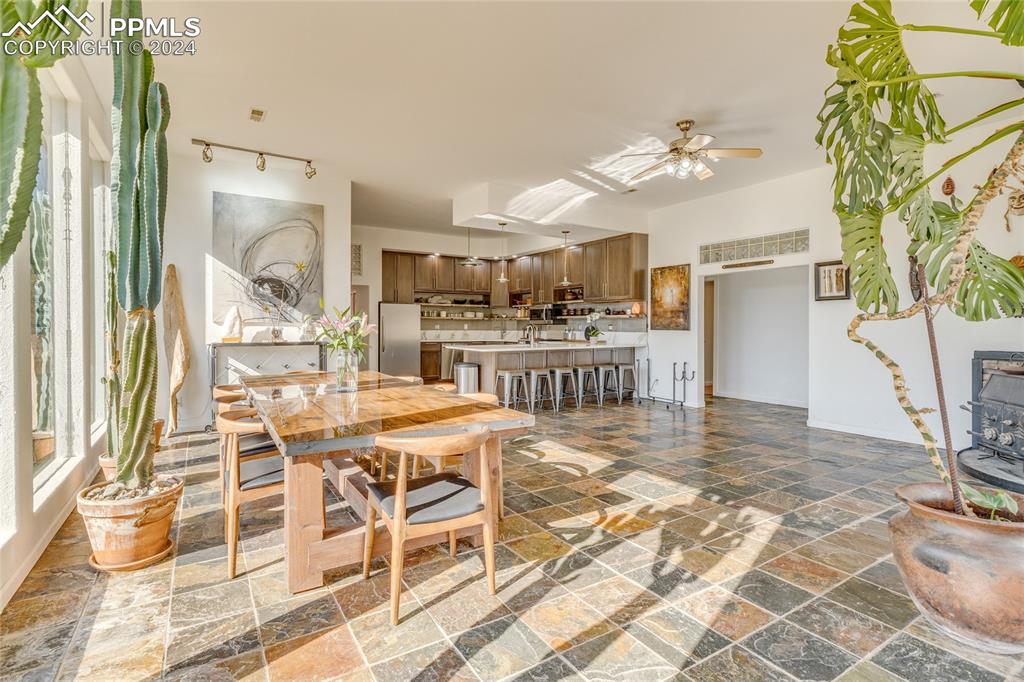 Image 9 of 47: Dining room with dark tile flooring and ceiling fan