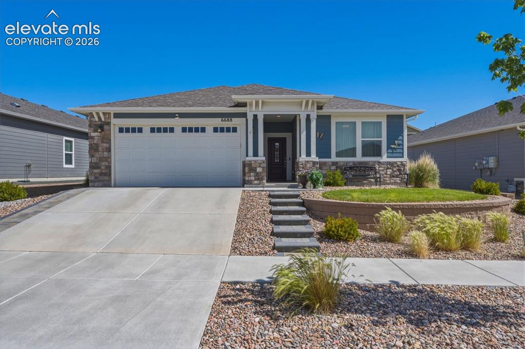 Image 1 of 25: Single-story residence featuring a two-car garage, stone and siding exterio