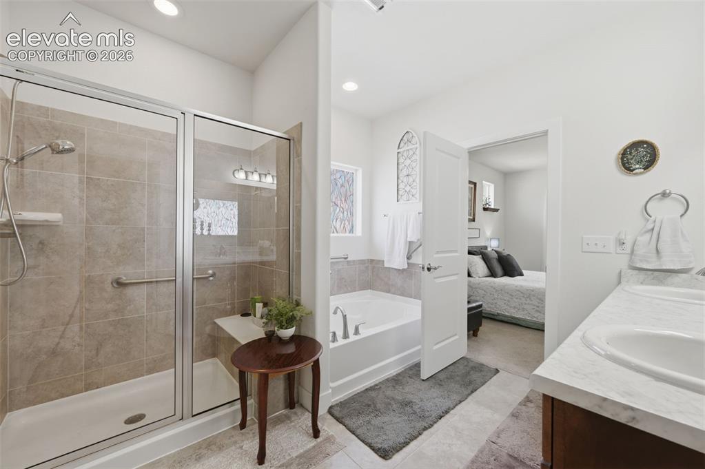 Image 12 of 25: Bathroom featuring a glass-enclosed shower with tile surround, a built-in t