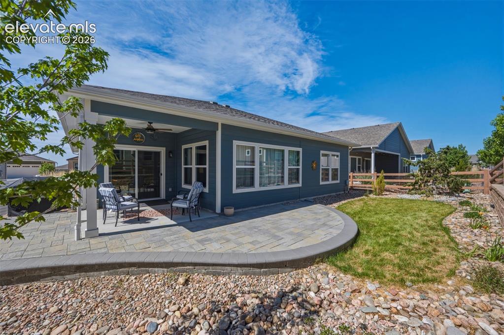 Image 21 of 25: Rear exterior featuring a covered patio with a ceiling fan, sliding glass d