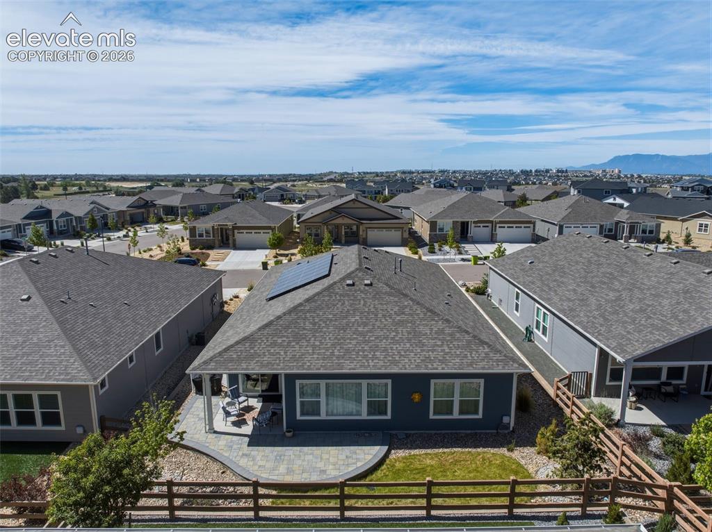 Image 24 of 25: Shingle roof home featuring solar panels and a covered back patio