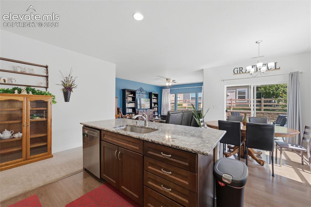 Image 4 of 25: Kitchen island with granite countertop, integrated sink, and stainless stee