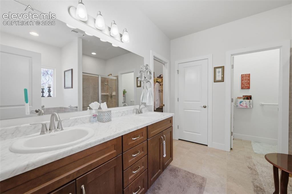 Image 9 of 25: Dual vanity with white oval sinks, brushed nickel faucets, and a light-tone