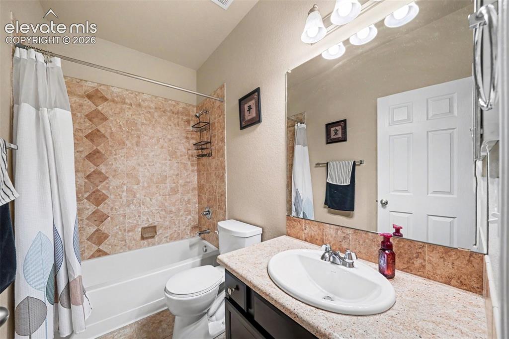 Image 12 of 21: Bathroom featuring a combination shower and tub with patterned tile surroun