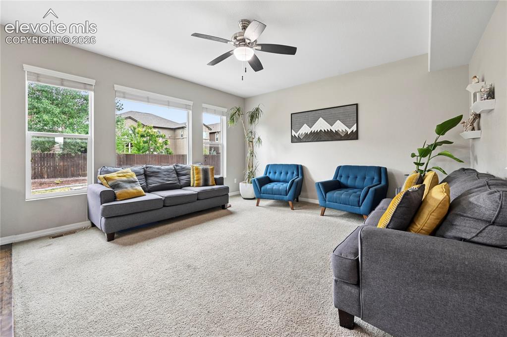 Image 10 of 48: The living room enjoys so much daylight from a whole wall of windows that o