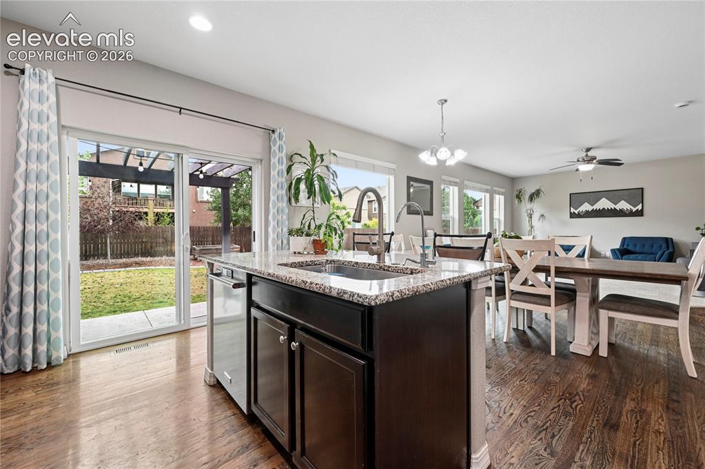 Image 13 of 48: The kitchen island with its farmhouse sink and granite counters doubles as 
