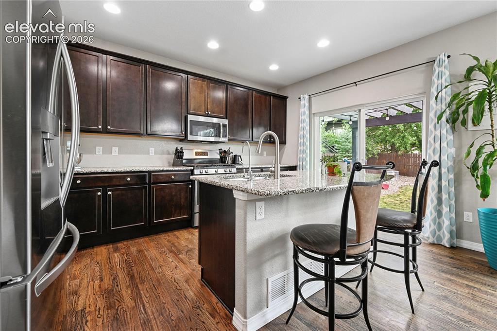 Image 14 of 48: The kitchen is upgraded to a gas range, plus 42" upper cabinetry, granite c