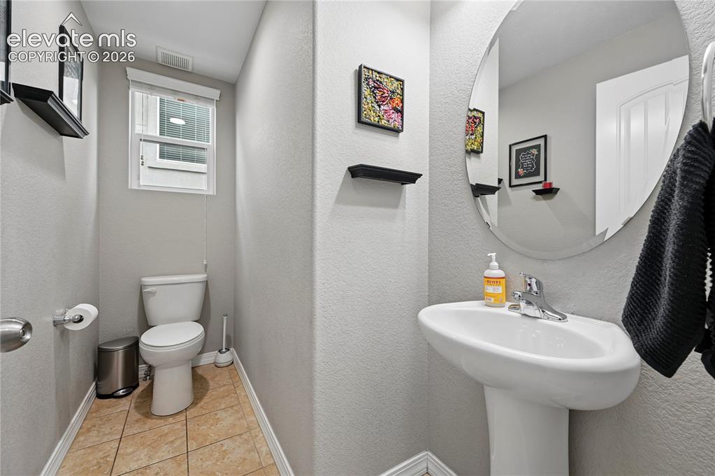 Image 18 of 48: The main floor half bathroom is tucked just around the corner from the main