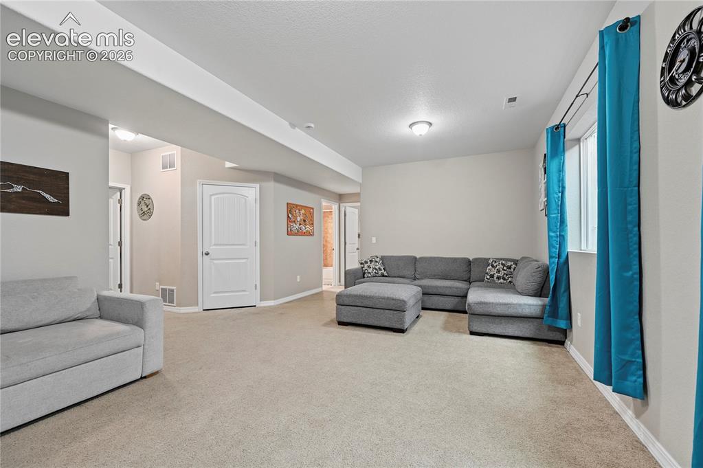 Image 39 of 48: The family room separates the two additional basement bedrooms, giving them
