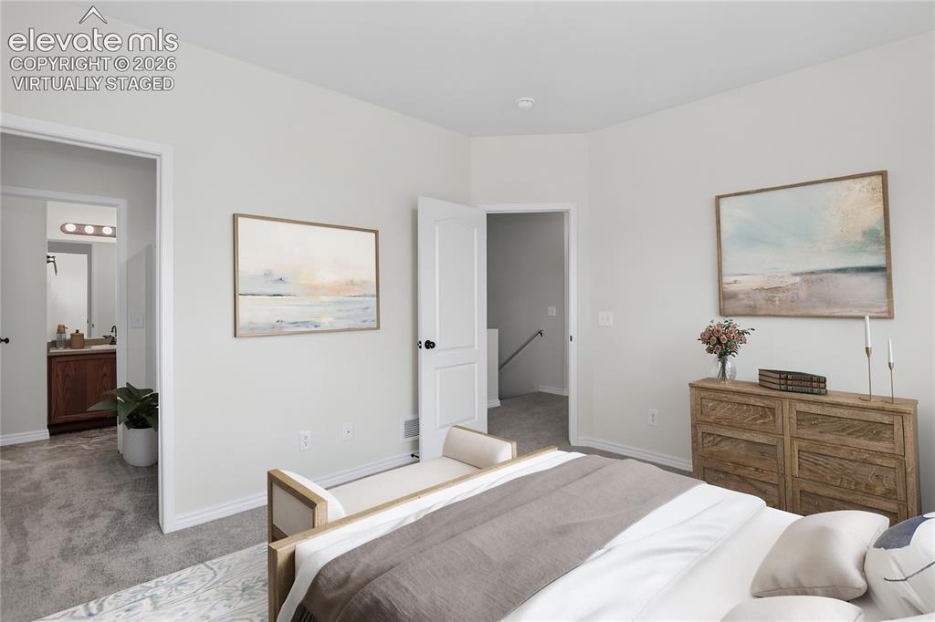 Image 11 of 32: Virtually staged primary bedroom with ensuite bath