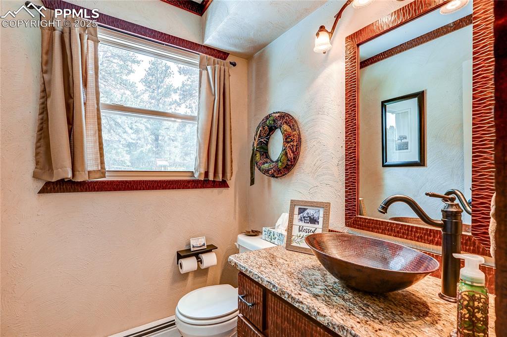 Image 16 of 49: Half bathroom featuring vanity and a baseboard radiator