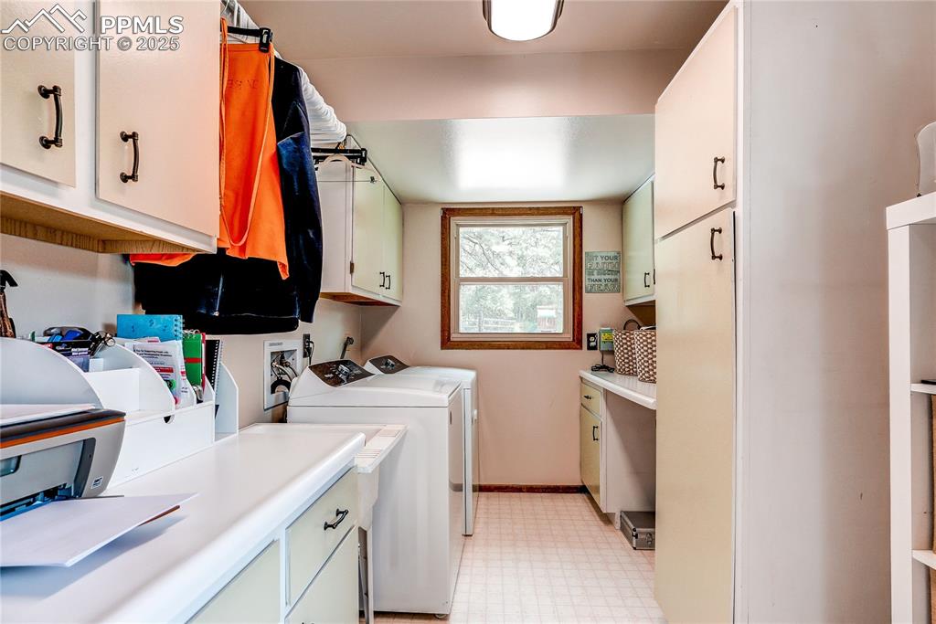 Image 17 of 49: Laundry room with cabinet space, washing machine and clothes dryer, and lig