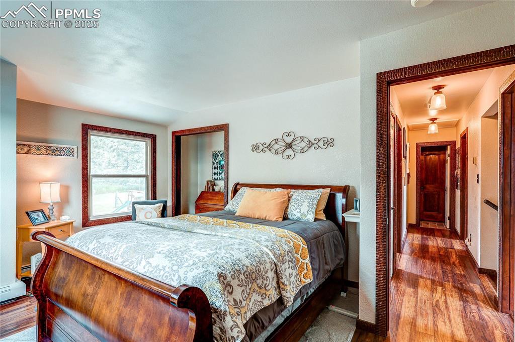 Image 26 of 49: Bedroom with dark wood-type flooring and baseboards
