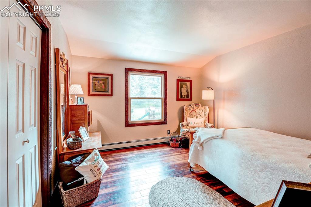 Image 27 of 49: Bedroom with hardwood / wood-style floors, vaulted ceiling, and baseboard h
