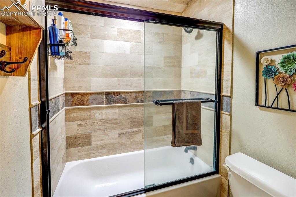 Image 28 of 49: Full upstairs bathroom featuring shower / bath combination with glass door
