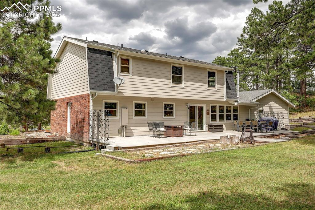 Image 34 of 49: Rear view of property with a yard, a shingled roof, a wooden deck, a patio,