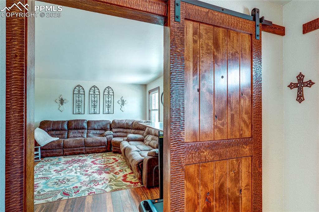 Image 4 of 49: Living area with wood finished floors and a barn door