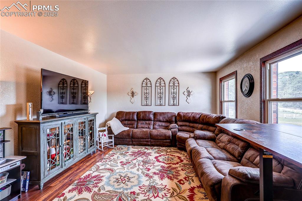 Image 5 of 49: Living room featuring a textured wall and wood finished floors