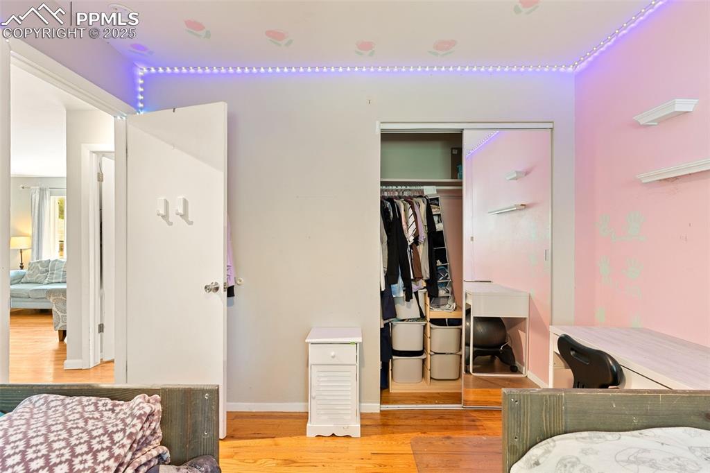 Image 24 of 38: Bedroom with wood finished floors and a closet
