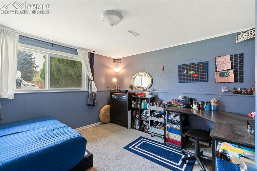 Image 31 of 38: Carpeted bedroom featuring ornamental molding and a desk