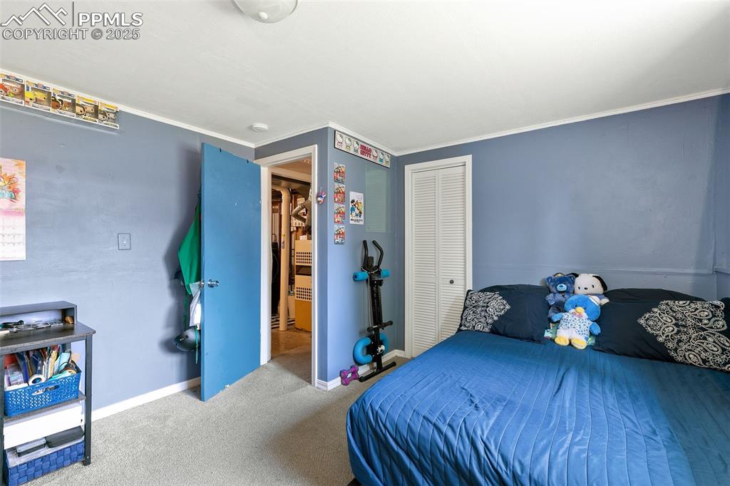 Image 32 of 38: Carpeted bedroom with a closet and crown molding