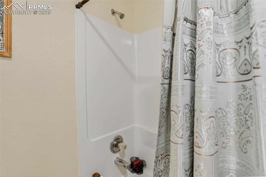 Image 17 of 26: Full bathroom with shower / bathtub combination with curtain